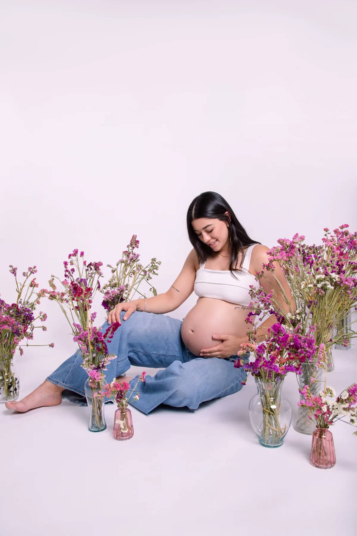 Mujer embarazada sentada entre flores
