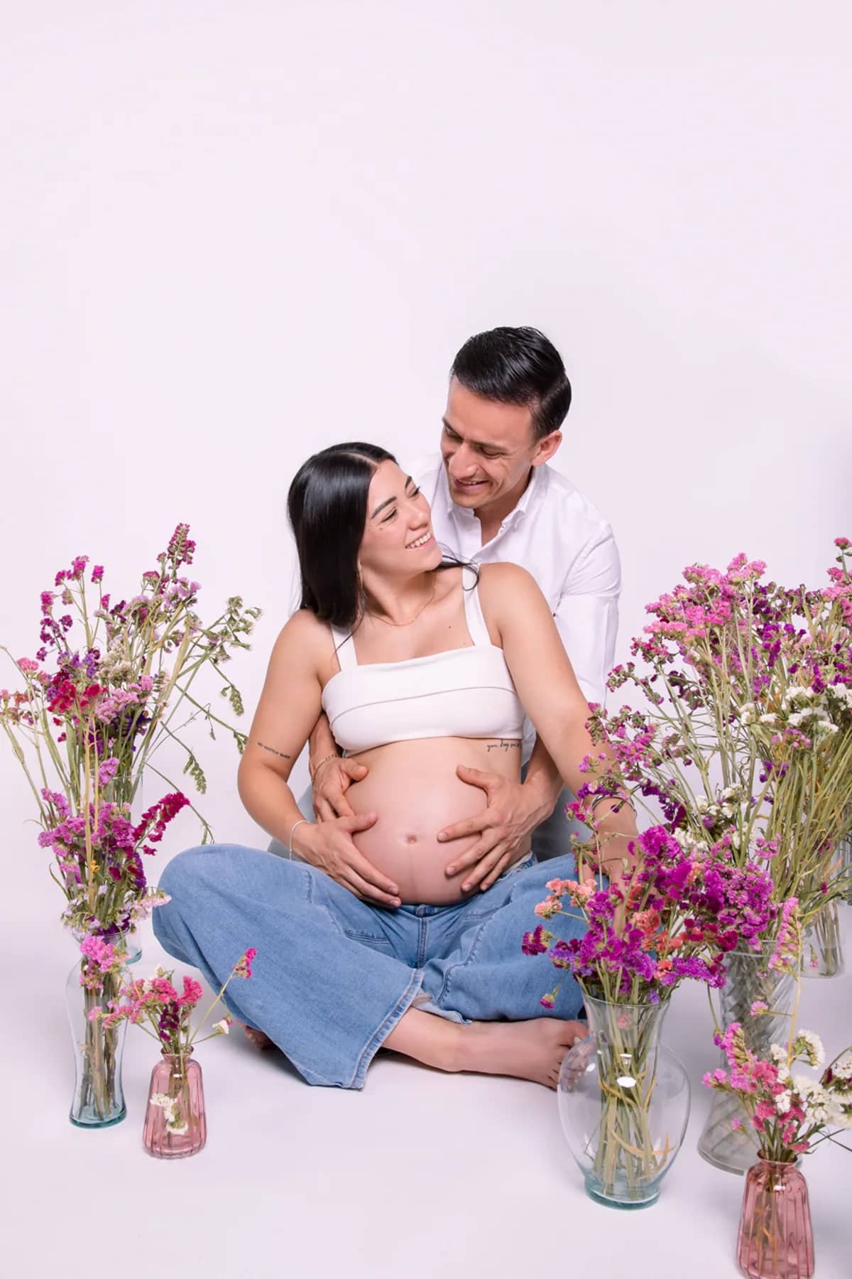 Pareja abrazada entre flores en estudio