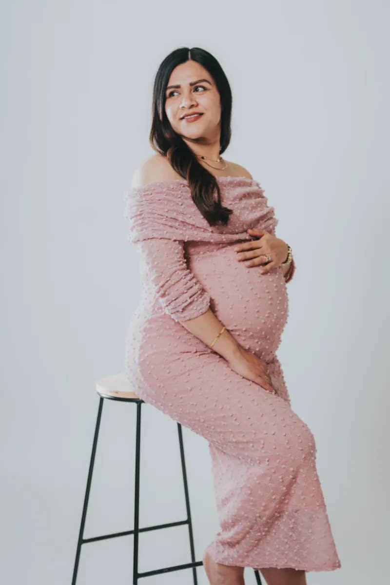 Mujer con vestido rosa en banco